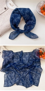 Detailed close-up of dark blue floral cotton linen scarf with white leaf patterns