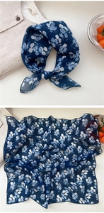 Detail of navy blue floral cotton linen scarf with white tulip pattern in soft light