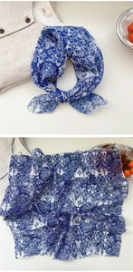 Detail of floral cotton linen scarf with blue and white porcelain pattern and elegant drape