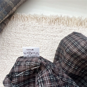 Gros plan sur le tissu 100% coton avec un motif à carreaux marron café classique
