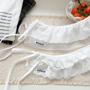 Detail of white floral lace layering skirt with ruffled tulle and satin ribbons