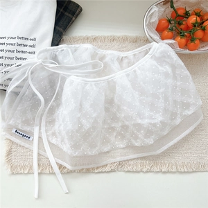 Detail of white lace mesh wrap skirt with polka dots and side drawstring tie