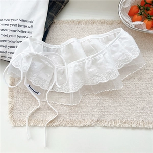 Macro detail of white lace embroidery ruffles and delicate drawstring on a woven texture