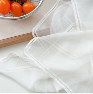 Close-up of semi-transparent lightweight mesh scarf fabric with delicate hollow stitching