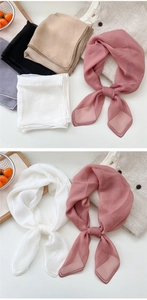 Detailed view of lightweight solid color square scarves in assorted soft pastel tones