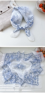Detail of floral chiffon scarf featuring blue flowers and strawberry patterns on white silk