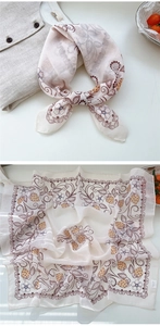 Detail of floral silk scarf with retro strawberry pattern and wavy borders on linen shirt