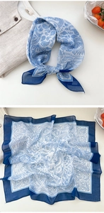 Close-up of blue paisley square scarf with delicate floral patterns and soft silk texture