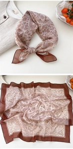 Detail of vintage paisley pattern on a brown and beige silk-like square neck scarf