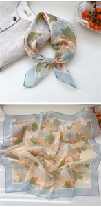 Detailed macro view showing the floral pattern and silk texture of the vintage square scarf
