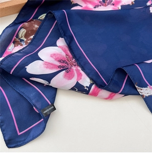 Detailed macro view of navy blue floral scarf material with 100% polyester care label