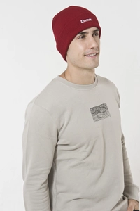 Close-up of burgundy knit beanie with white Drunken embroidery and grey sweatshirt