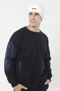 Detail view of black knit pullover featuring navy nylon patchwork and side zipper pocket