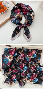 Detail view of floral silk scarf with red rose pattern and smooth satin texture finish