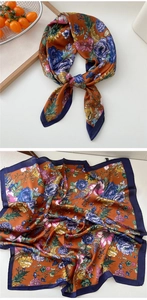 Detail of floral silk scarf in burnt orange with vintage patterns and blue borders