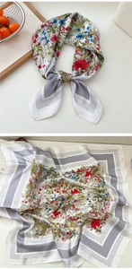 Detailed view of floral silk neck scarf with grey borders and colorful flower patterns