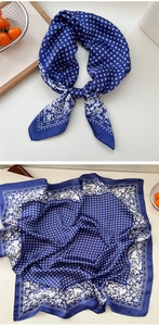 Macro detail of dark blue floral silk scarf featuring white rose patterns and geometric grids