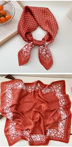 Detail of red floral satin scarf featuring geometric patterns and white rose print details