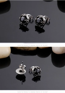 Detail of vintage titanium steel stud earrings with black gemstone and engraved patterns
