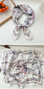 Detailed close-up of floral and bird print silk scarf with smooth satin texture
