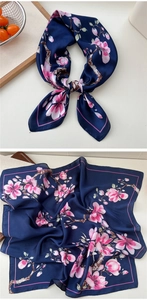 Detail of navy blue satin floral scarf with pink magnolia pattern and silky texture