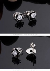 Macro detail of retro steel studs with clear zircon and black floral engraved edges