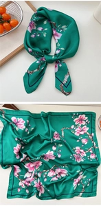 Detailed close-up of emerald green floral silk scarf with elegant pink blossom patterns