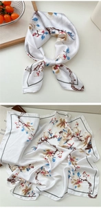 Detail of floral silk scarf showing plum blossom print and elegant satin texture