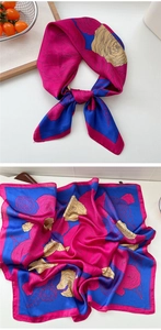 Detailed close-up of floral silk scarf featuring bold rose prints and satin texture finish