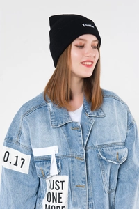 Close-up of Drunken embroidery on black knit beanie and denim jacket patches