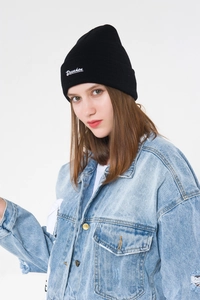 Close-up of black beanie with white Drunken script embroidery and knit texture