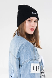 Close-up of Drunken script embroidery on black knitted beanie with street style look