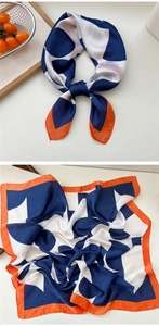 Detail of floral silk scarf featuring geometric color blocking in navy blue and orange