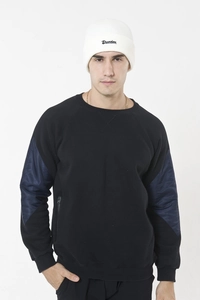 Close-up of a white knit beanie featuring Drunken embroidery on the brim with high detail