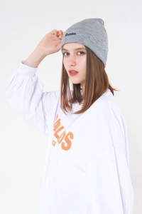 Close-up of black cursive embroidery on a grey knit beanie featuring a street style design