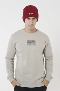 Detail view of the red Dreken knitted beanie with white Drunken embroidery on model