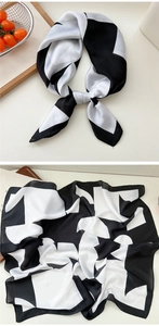 Detail showing geometric black and white silk scarf with a smooth satin finish and draped texture