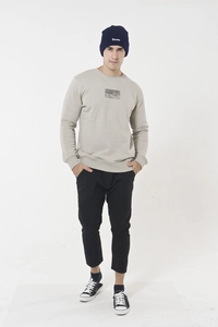 Full view of a man wearing a dark blue knit beanie with white embroidered lettering
