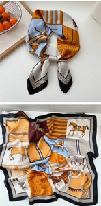 Close-up of orange floral silk scarf with equestrian horse pattern and satin finish