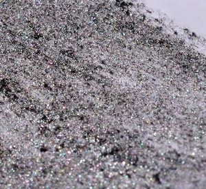 Vue macro d'une poudre à ongles chrome noir miroir avec des effets holographiques brillants