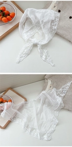 Detailed macro shot of white floral lace embroidery on a lightweight triangle headscarf