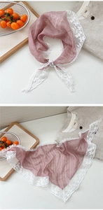Detail of dusty pink triangular scarf with white floral embroidery lace on light linen