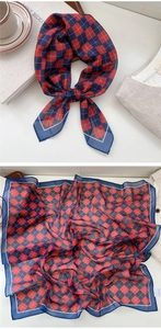 Detail of red and blue checkered silk scarf with navy trim shown in a lifestyle setting