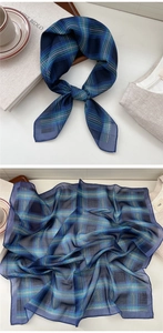 Macro detail of navy blue plaid silk scarf showing lightweight texture and check pattern
