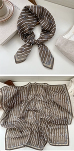 Close-up of silk scarf with equestrian horse motifs and classic brown stripes