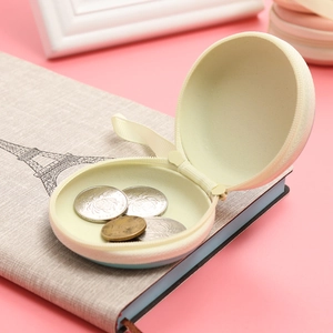 Macro view of blue round tinplate coin purse showing interior coins and zipper detail