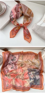Detailed close-up of a 100% silk floral square scarf with elegant orange and pink vintage patterns