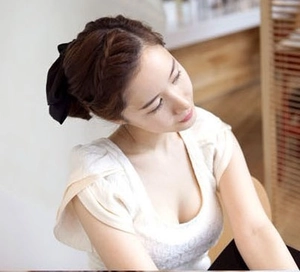 Schwarze übergroße Satin-Haarschleife gestylt auf geflochtenem Haar für elegante Looks
