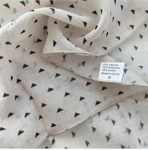 Close-up of cotton-blend scarf fabric with triangle patterns and care label details