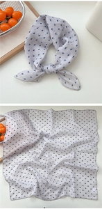 Close-up of white cotton linen square scarf with blue geometric triangle pattern detail